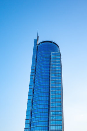 Modern skyscraper in blue under clear sky.