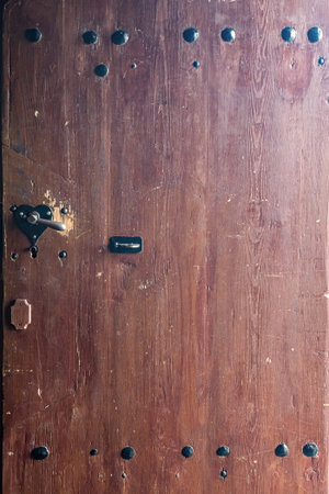 weathered, stained wooden door with a heart shaped handle.の写真素材