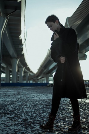 Young stylish woman urban walking under bridgeの写真素材