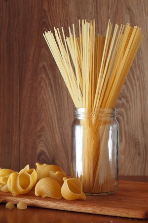 Spaghetti in a glass jar of pasta seashellsの写真素材