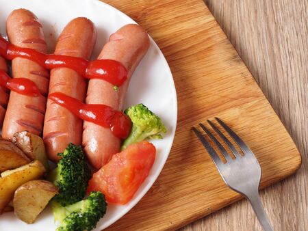 Sausages a plate of vegetables a forkの写真素材