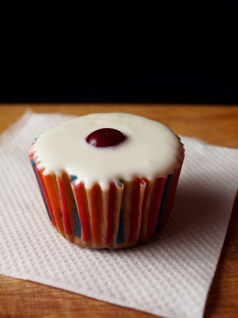 Cupcake in a paper colored basket on a napkinの写真素材
