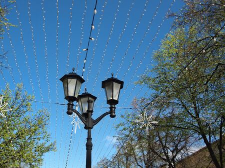 street lamp against the sky and garlands in the afternoonの写真素材