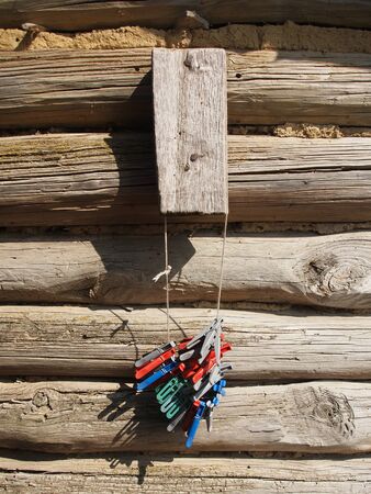 a bunch of clothespins on a log wallの写真素材