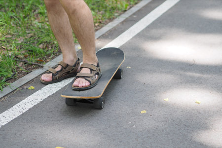 the man on the longboard is wearing sandals