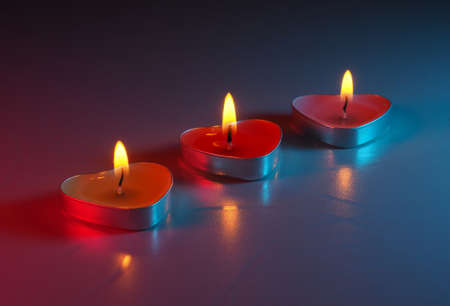 burning colored scented heart shaped candlesの写真素材
