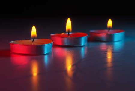 burning colored scented heart shaped candlesの写真素材