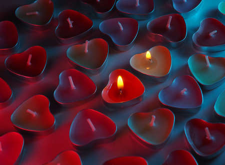 burning colored scented heart shaped candlesの写真素材