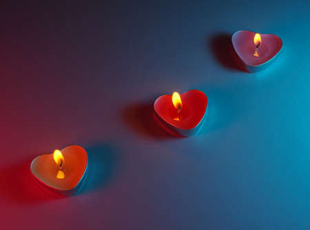 burning colored scented heart shaped candlesの写真素材
