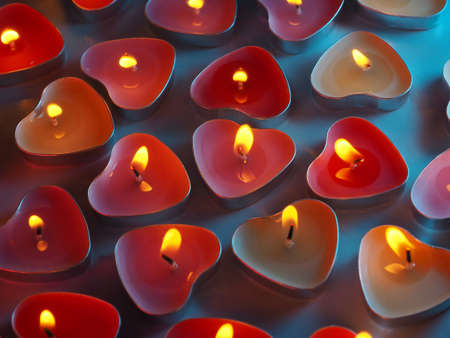 burning colored scented heart shaped candlesの写真素材