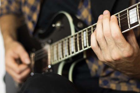 Young man playing music on guitarの写真素材