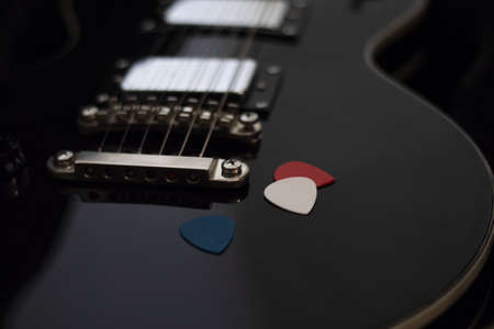 black guitar with mediators on dark backgroundの写真素材