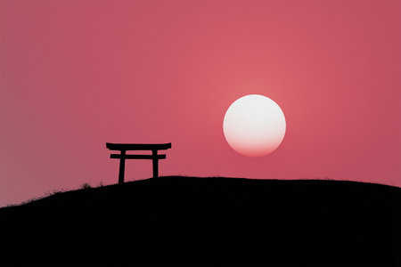 Sunset over a traditional torii gate on a grassy hillの素材