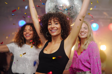 Friends celebrate together at a lively dance party in the clubの素材