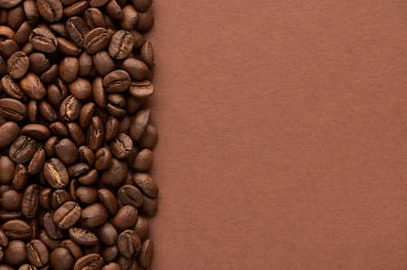 Roasted coffee beans on brown background with copy space. Close up top view. High quality photoの写真素材
