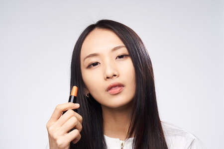 Woman asian paints makeup on face skin, woman enjoys makeup.の写真素材