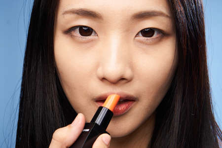 Woman asian paints makeup on face skin, woman enjoys makeup.の写真素材