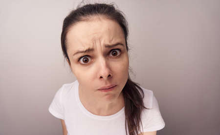 Woman with bulging eyes on a light background.の写真素材