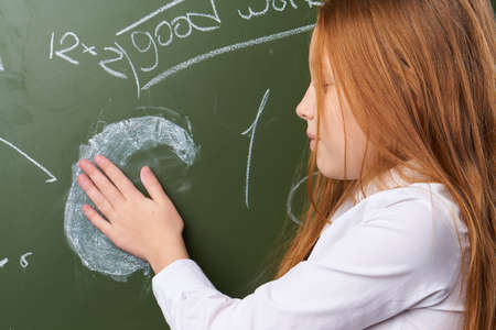 The schoolgirl erases the palm from the board.
