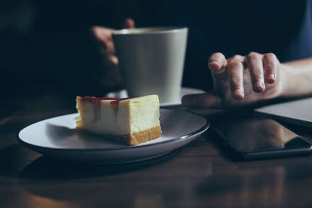 On the table is a telephone, a plate with cheesecake.の写真素材