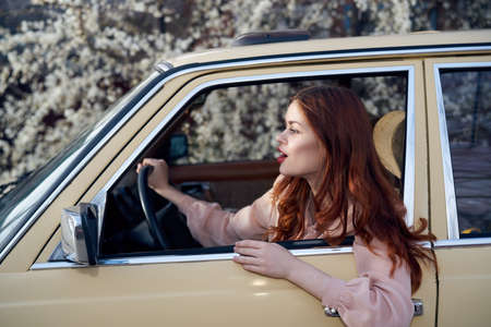Woman driving a car, a woman peeking out of a car window.