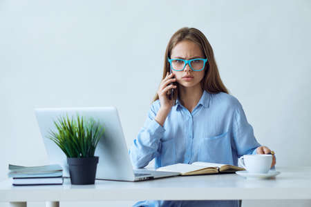 Business woman with glasses is talking on the phone.