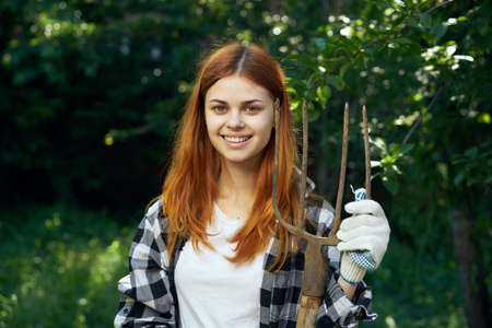 Woman with pitchforks working at the cottage.の写真素材