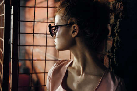 Woman in glasses on the background of the old wall.の写真素材