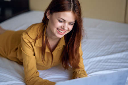Woman with a smile lies in bed.の写真素材