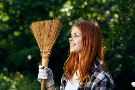 A woman with a broom in the country.の写真素材