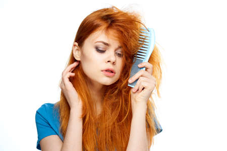 Woman with tangled hair, comb in hair on isolated background.の写真素材