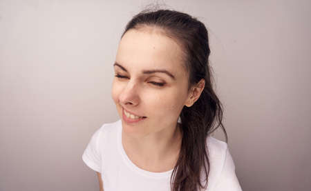 Woman with emotions, woman smiling on a light background.の写真素材