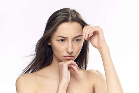 Serious woman, woman holding hands near face on isolated background.の写真素材