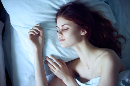 Woman is tired, woman is lying in bed, woman is sleeping.の写真素材