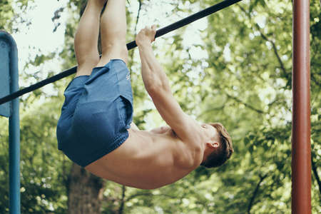 Athletic man pulls himself up, sport, healthy lifestyle, sporty appearance man.