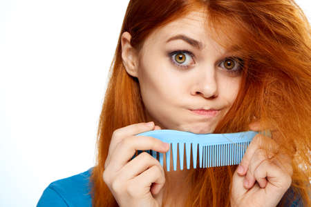 Woman holding a comb on isolated background portrait.