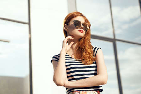 Woman in glasses on a background of a mirror building portrait.の写真素材
