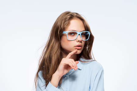 Female student, young woman with glasses, beautiful woman on a light background.の写真素材