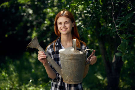 Woman in vegetable garden, young woman with watering can, woman watering grass.の写真素材