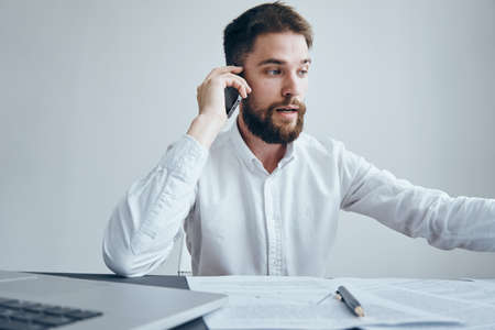 Businessman talking on the phone, businessman with documents, businessman on a light background.の写真素材