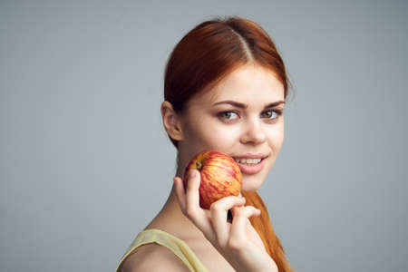 Woman with apple, diet, healthy eating, woman holding apple on gray background.