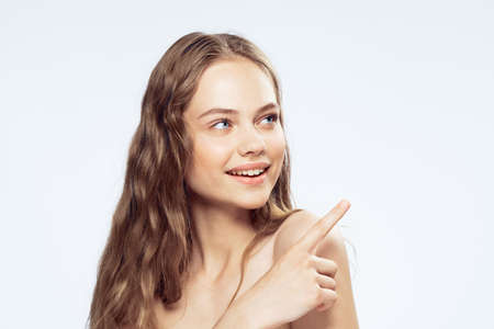 Woman smiling, woman showing on empty space, woman on light background.の写真素材