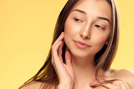 Woman with a clean face, woman on a yellow background portrait.