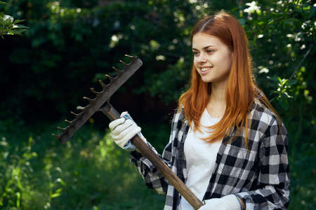 Woman with a rake, woman in a garden.の写真素材
