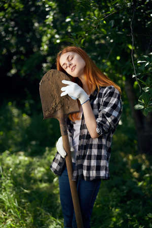 Woman with shovel, woman leaning on shovel, woman in vegetable garden.の写真素材