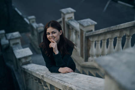 Woman smiling, woman clasped on the railing, woman on the staircase background.の写真素材
