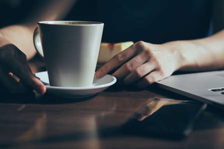 Woman with a mug of coffee, coffee, mug, phone, laptop.の写真素材