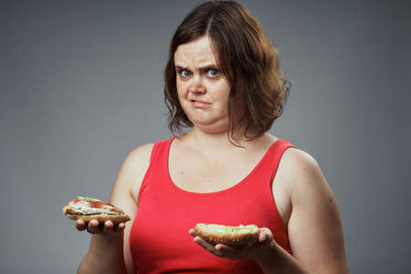Food, a hamburger, a woman shared a hamburger, a woman on a gray background.