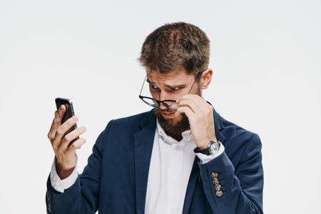 Business man with a beard, business man lowers a point, business man looks into the phone, a man on a white background.の写真素材
