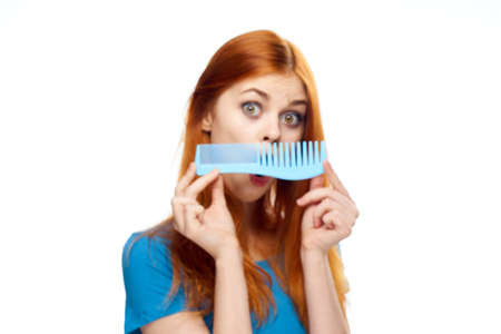 Hair, hairdo, surprise, girl on a white background, girl on a white background, the girl is holding a comb.の写真素材